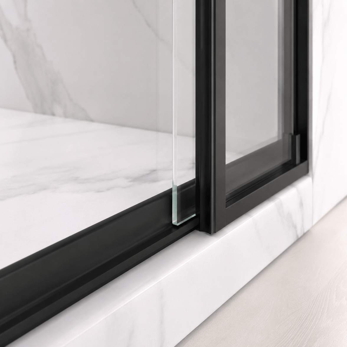 Bottom guide detail on Jade matte black semi-frameless sliding shower door