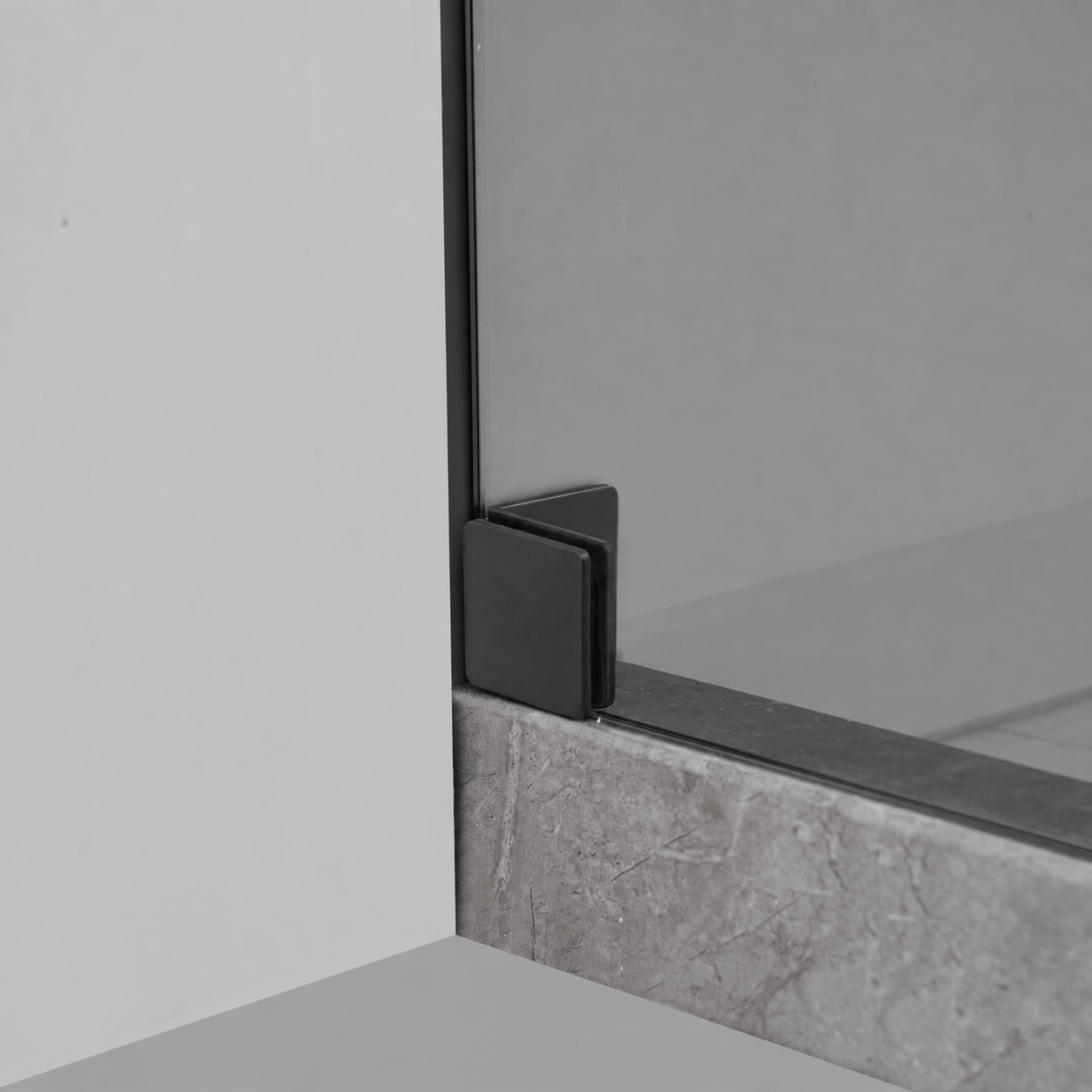 Bottom wall bracket detail on Jade matte black frameless shower door