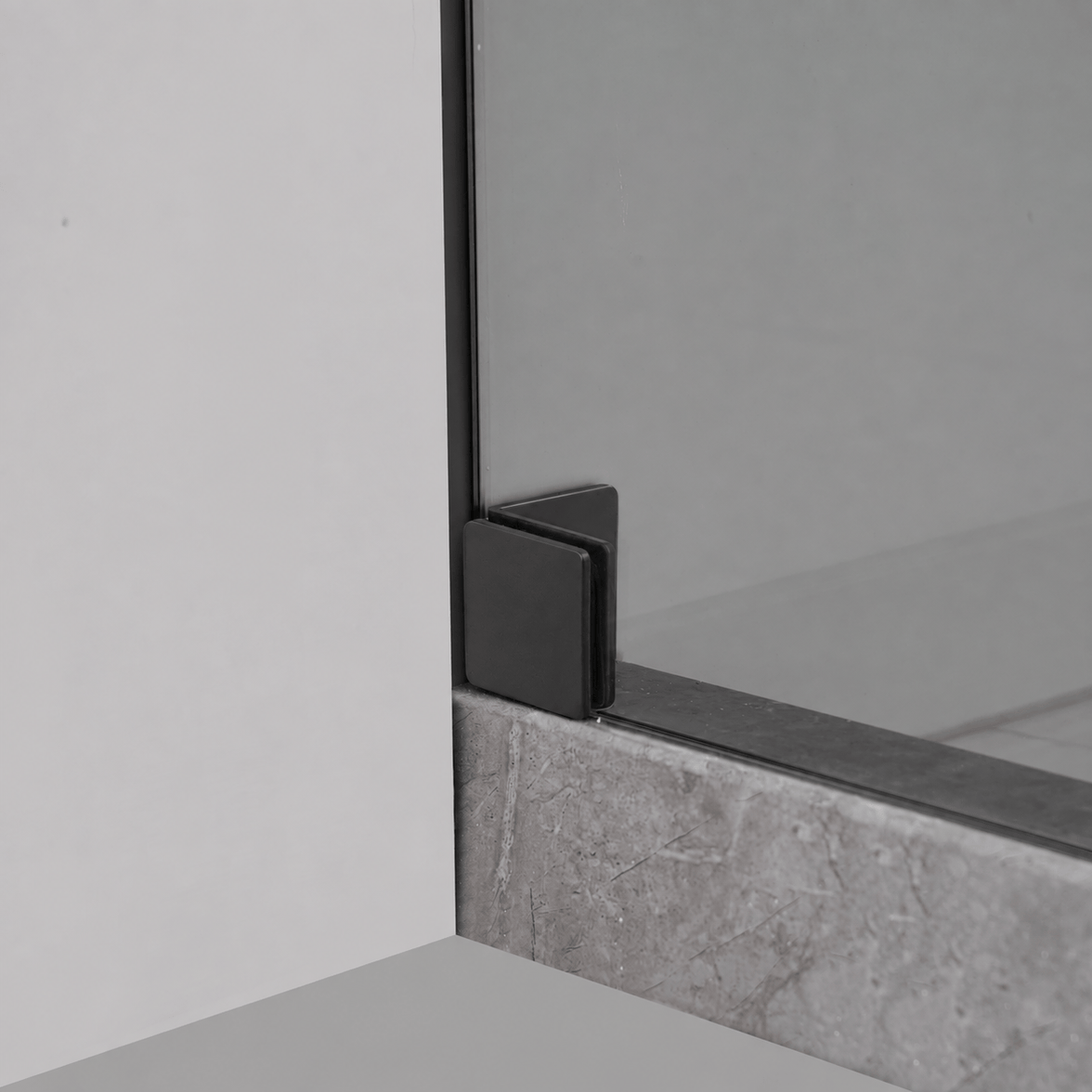 Bottom wall bracket detail on Jade matte black frameless shower door